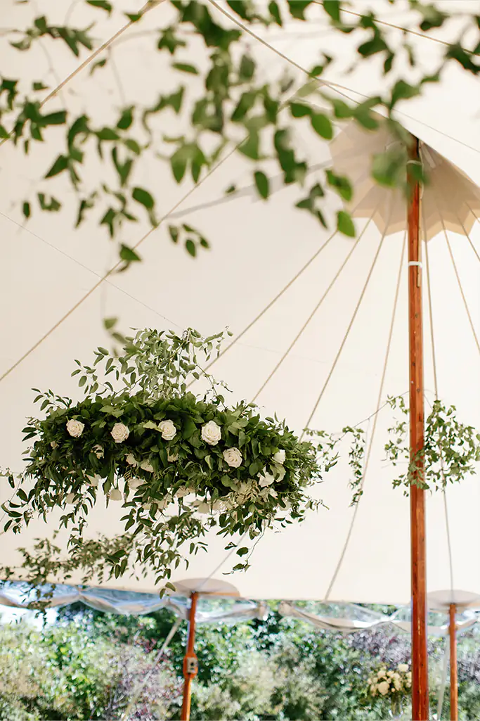 Hanging flower arrangements from sailcloth tent