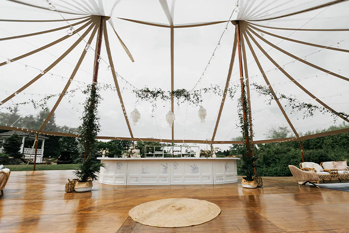 Full bar and dance floor under wedding tent