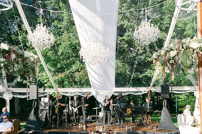 Band playing under a clear wedding tent rental 